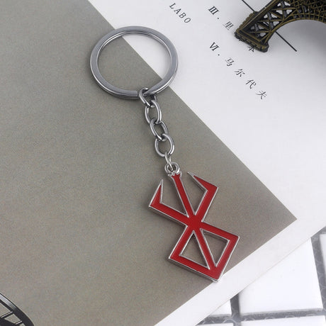 Berserk Game Logo Keychain - Show off your love for the iconic anime and game series with our officially licensed PS4 keychain. Made from durable metal, this keychain features the iconic Berserk logo and sword design, perfect for any fan to add to their collection. Order now and add a touch of anime style to your everyday life!